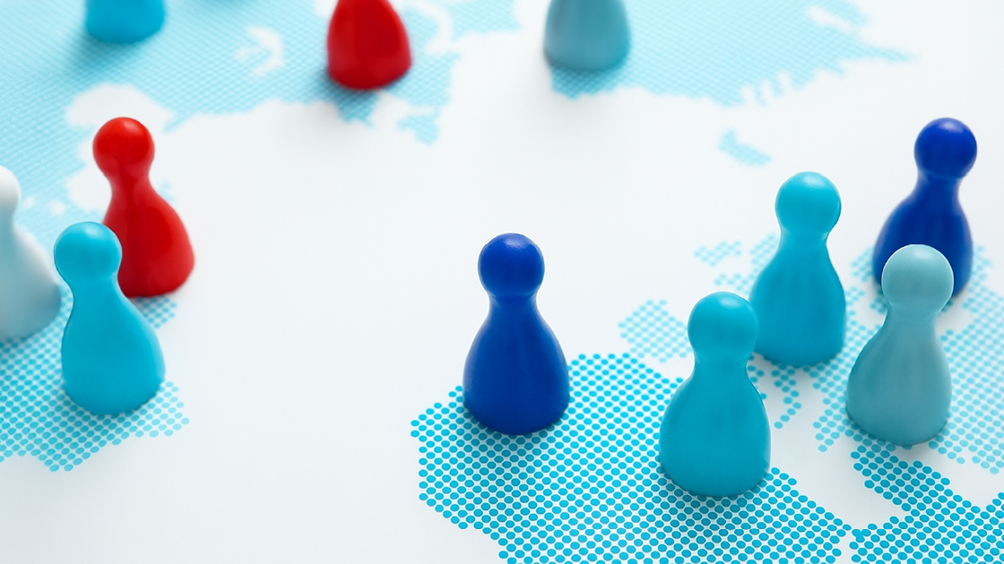 Colorful game pieces on a world map representing global strategy and market expansion for B2B companies